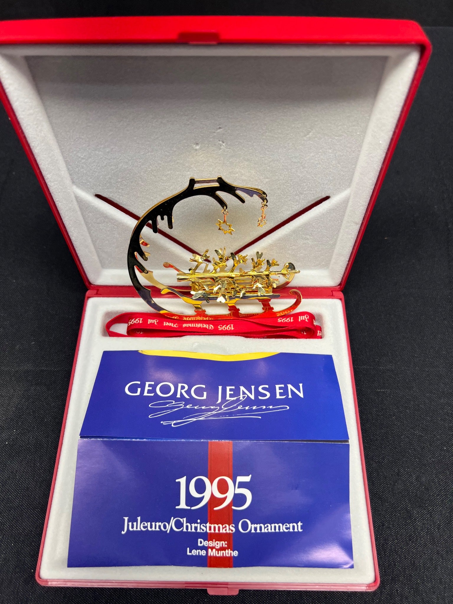 Georg Jensen 1995 Christmas ornament in a red and white box with a blue card.
