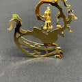 Gold dragon-shaped object with a figure on top against a gray background