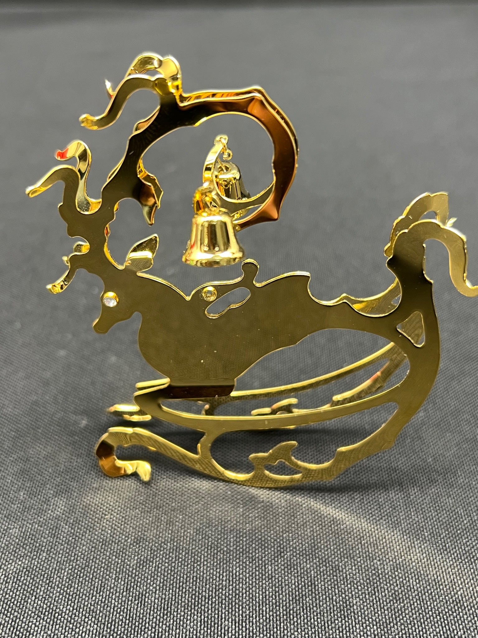 Gold sleigh with reindeer and bell on a gray background