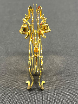 Gold jewelry stand with decorative elements on a gray background