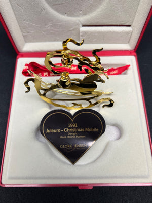 Gold Christmas mobile ornament with a heart-shaped tag in a box
