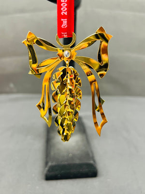 Gold decorative item on a stand with a red ribbon