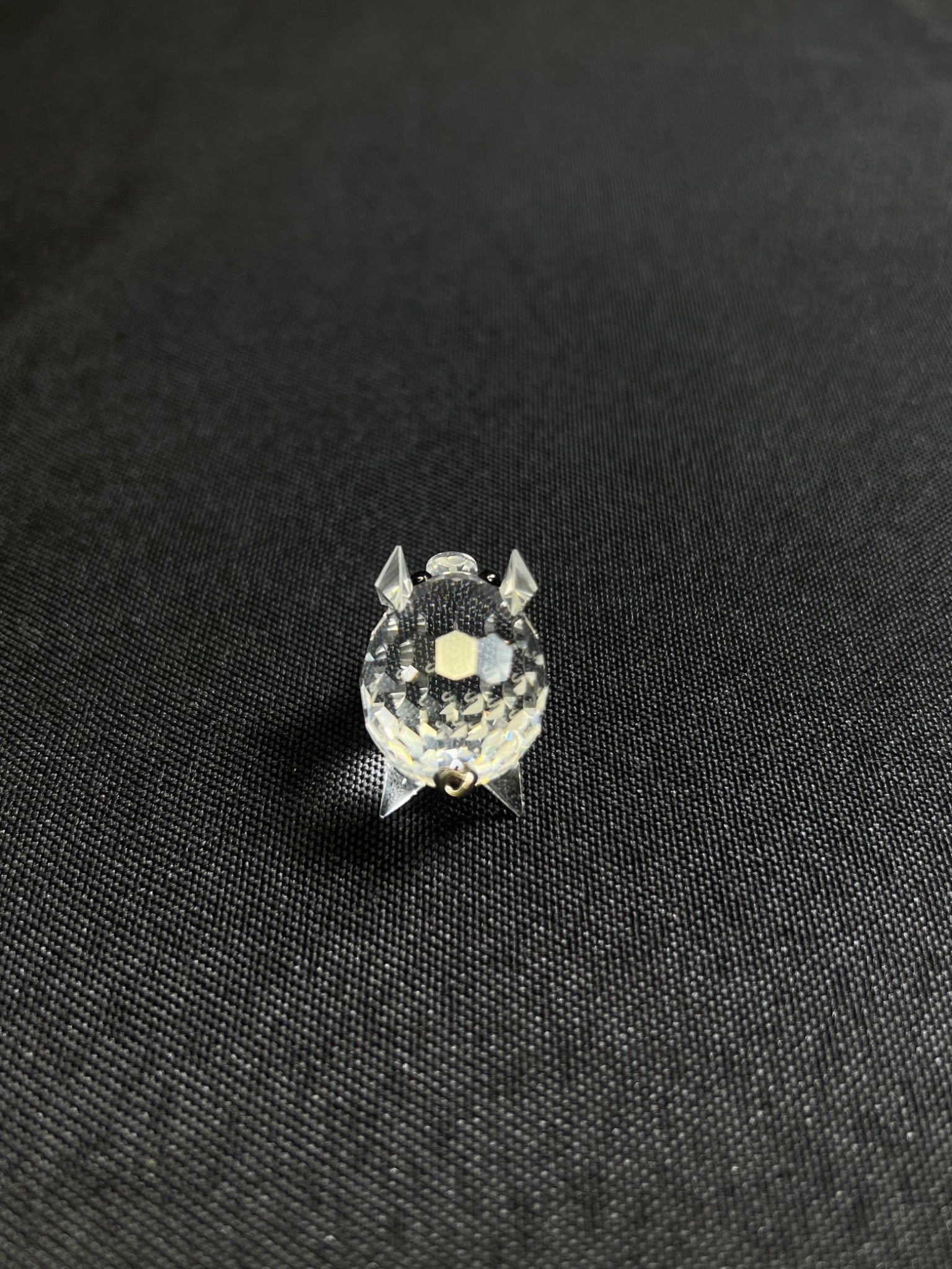 Small round object with a textured surface on a black fabric background