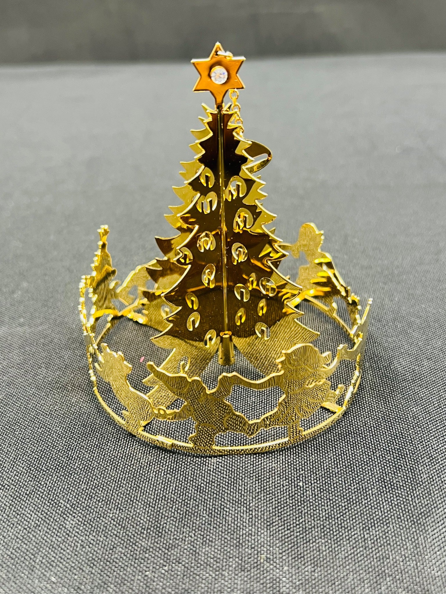 Gold Christmas tree-shaped cutout on a gray background