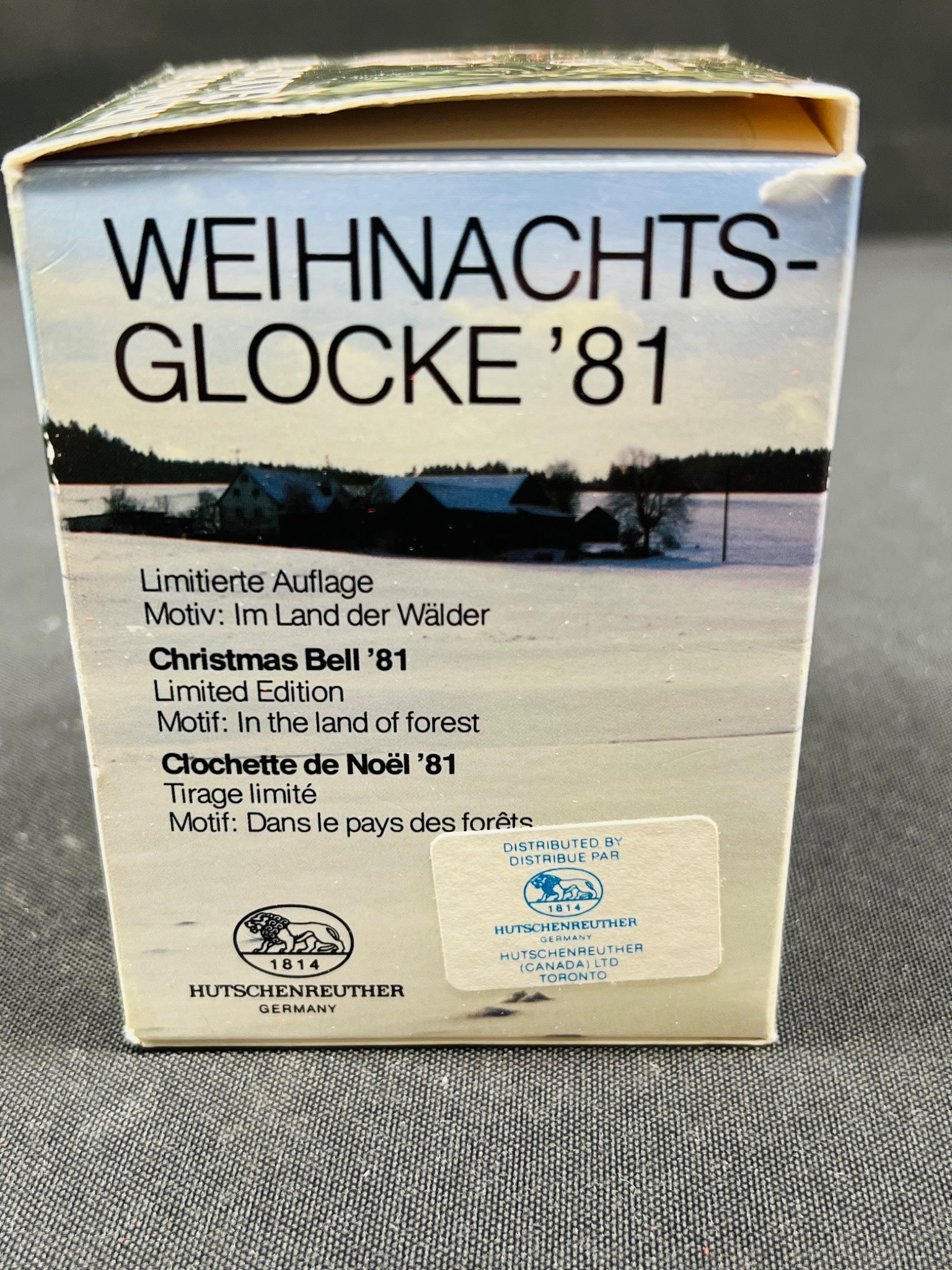 Box of 'Weihnachts-Glocke '81' Christmas bell with winter scene and text on a gray background
