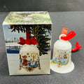 Decorative bell with festive design next to its packaging on a gray surface