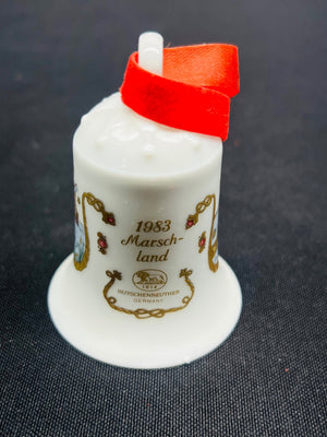 White ceramic thimble with red top on a dark textured background
