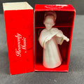 Decorative angel figurine in a red box with 'Heavenly Music' text on a gray background
