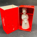 Small white angel figurine in a red box with 'Festive' branding on a gray surface.