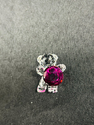 Crystal bear brooch with a red gem on a gray fabric background