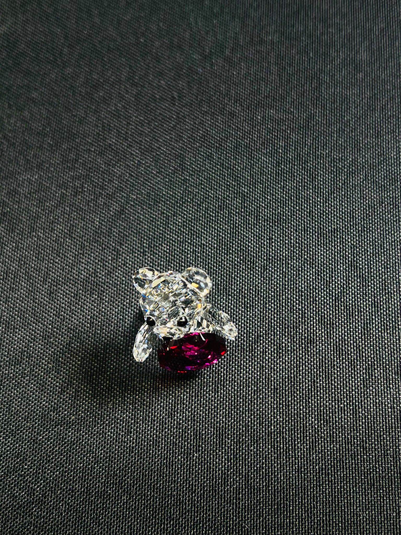 Silver ring with a purple gemstone on a dark fabric background