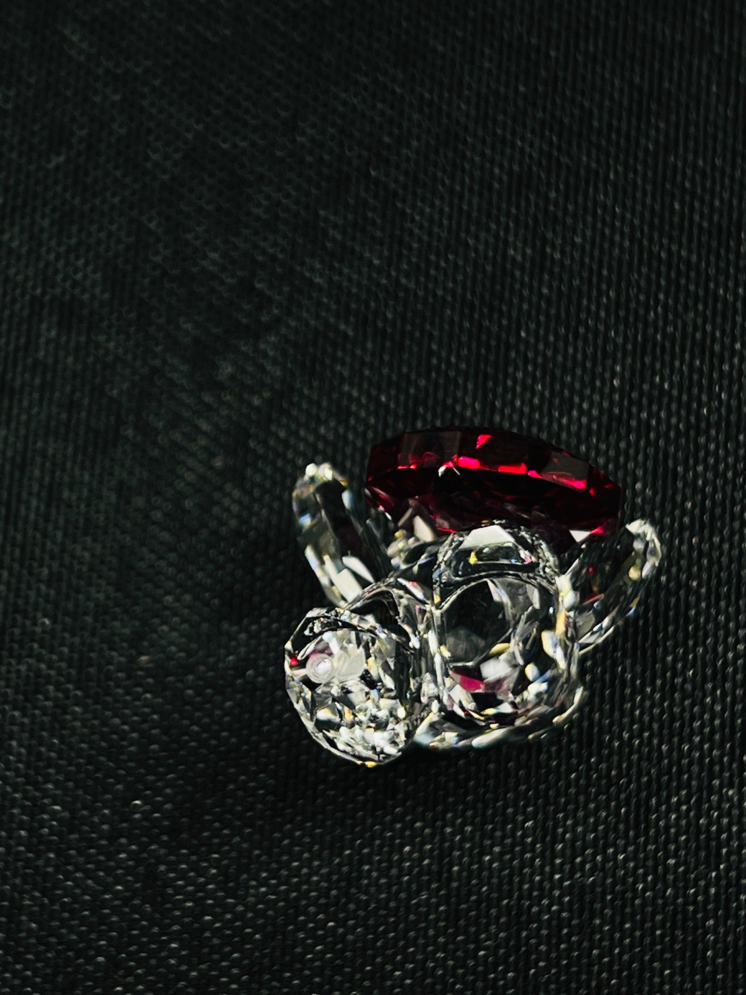Ring with red gemstone and clear crystals on a black background