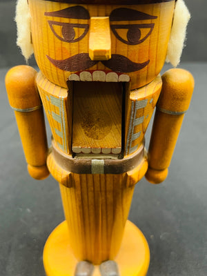 Wooden nutcracker figure with a mustache on a dark background
