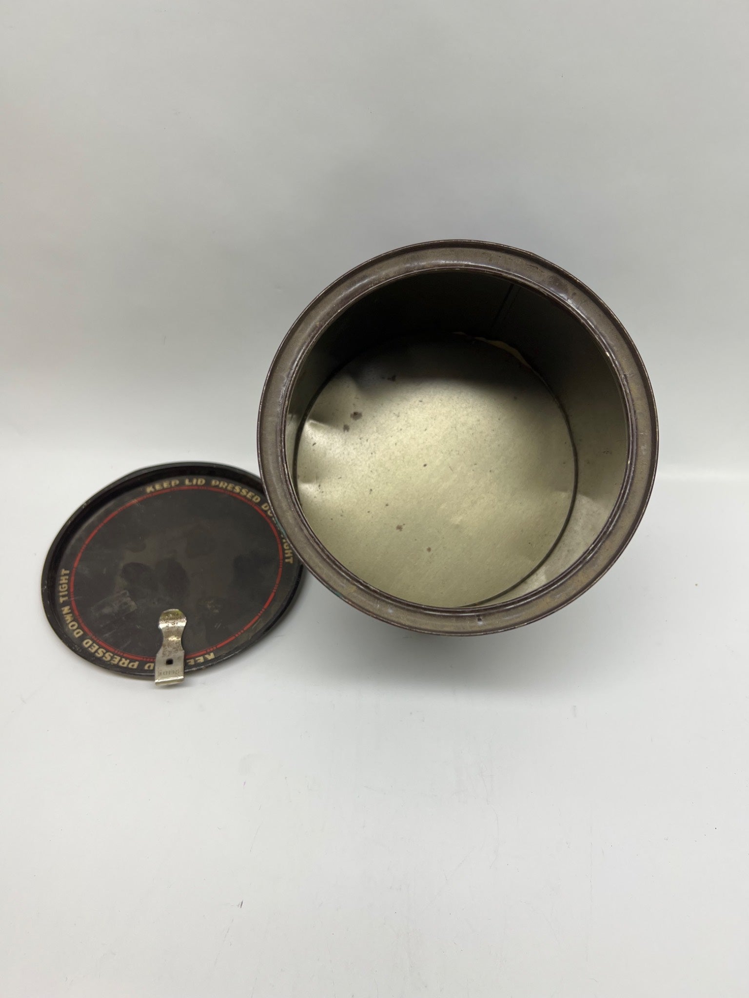 Open cylindrical container with a metallic interior on a white background